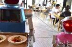 Robot couple Xiaolan and Xiaotao carry food at a restaurant in Jinhua